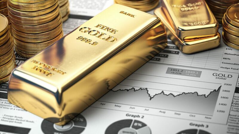 Gold bar, ingots and coins on financial report.